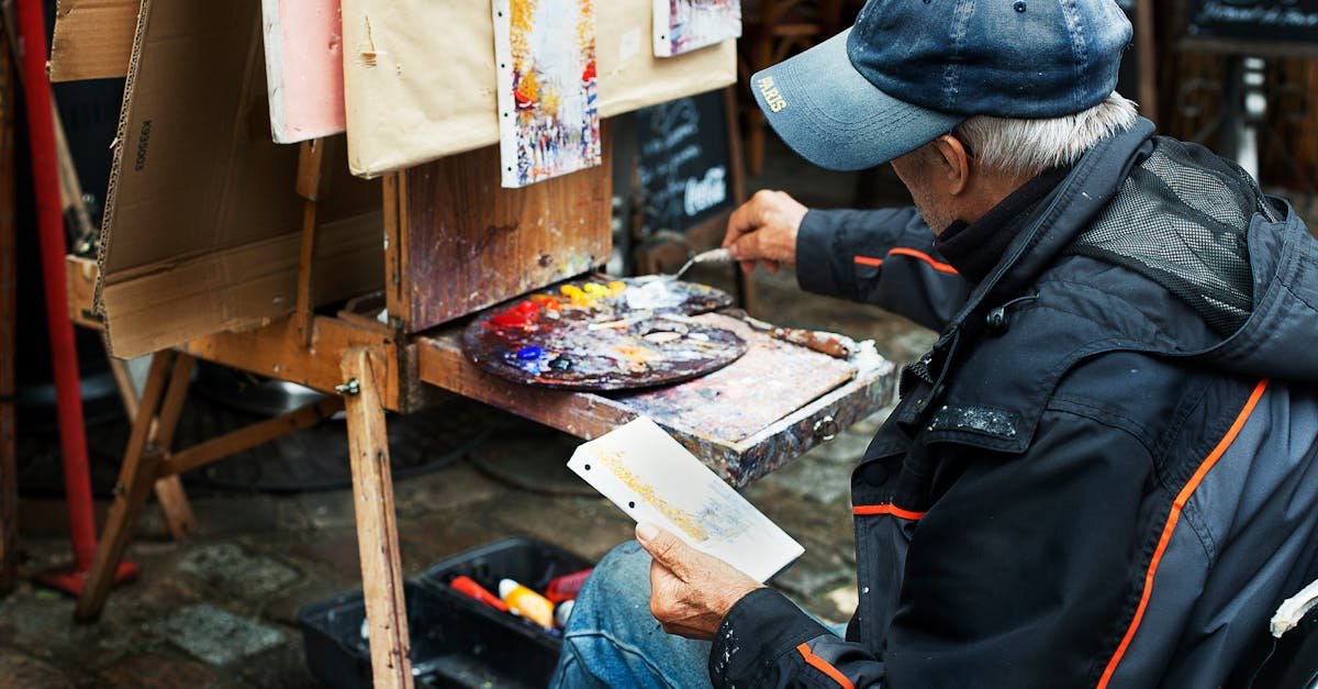 A street artist paints colorful abstracts on canvas, showcasing vibrant creativity in an outdoor setting.