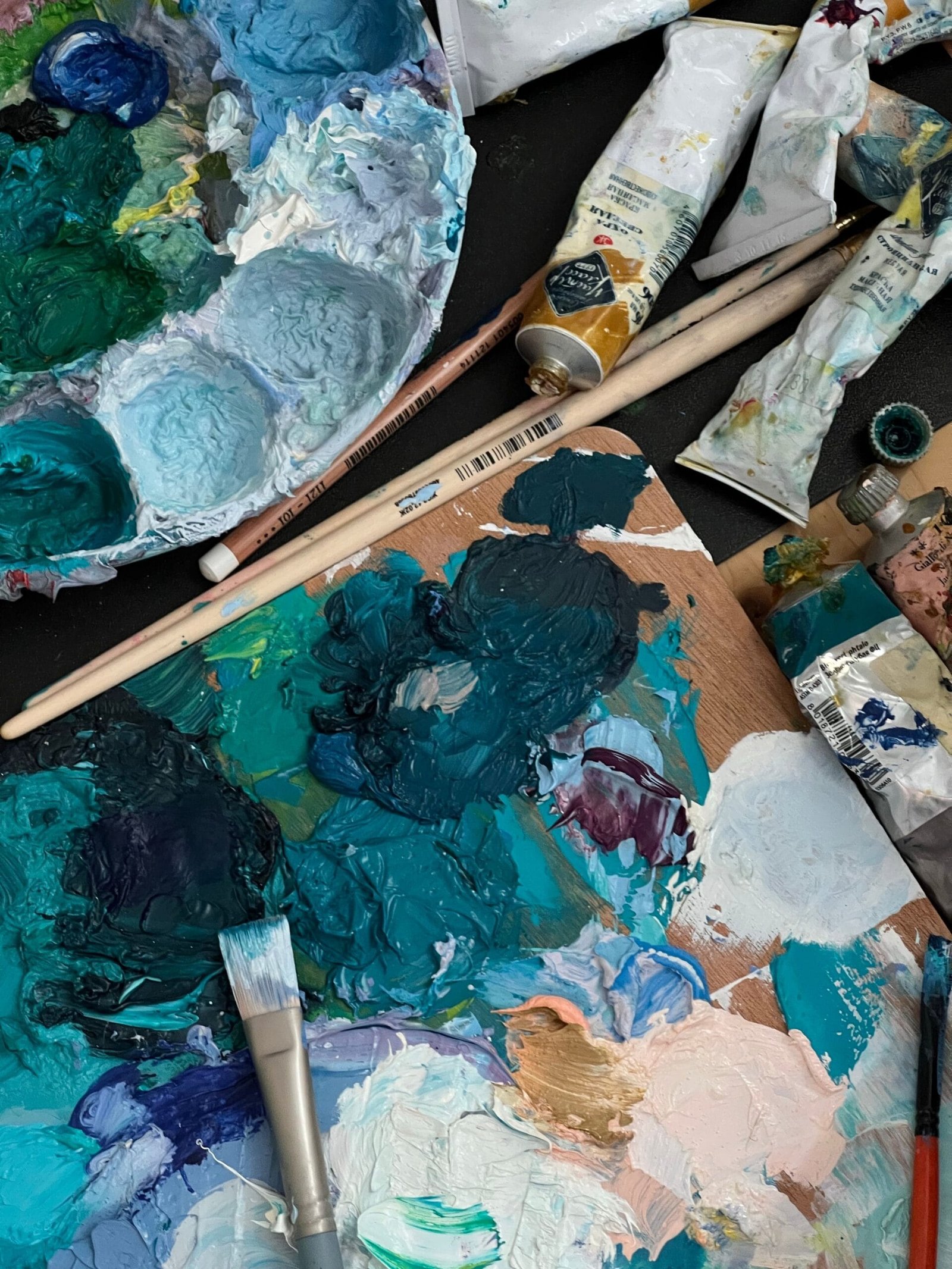 A close-up view of a colorful artist's palette with paint tubes and brushes, ideal for an art theme.